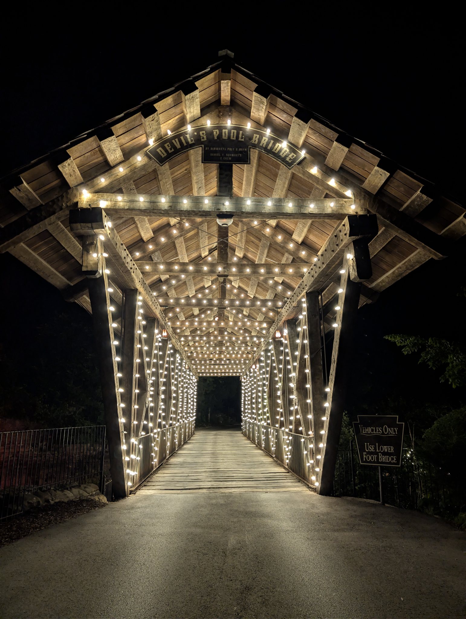 Devil's Pool Bridge illuminated with string lights at night at Big Cedar Lodge near Branson, Missouri
