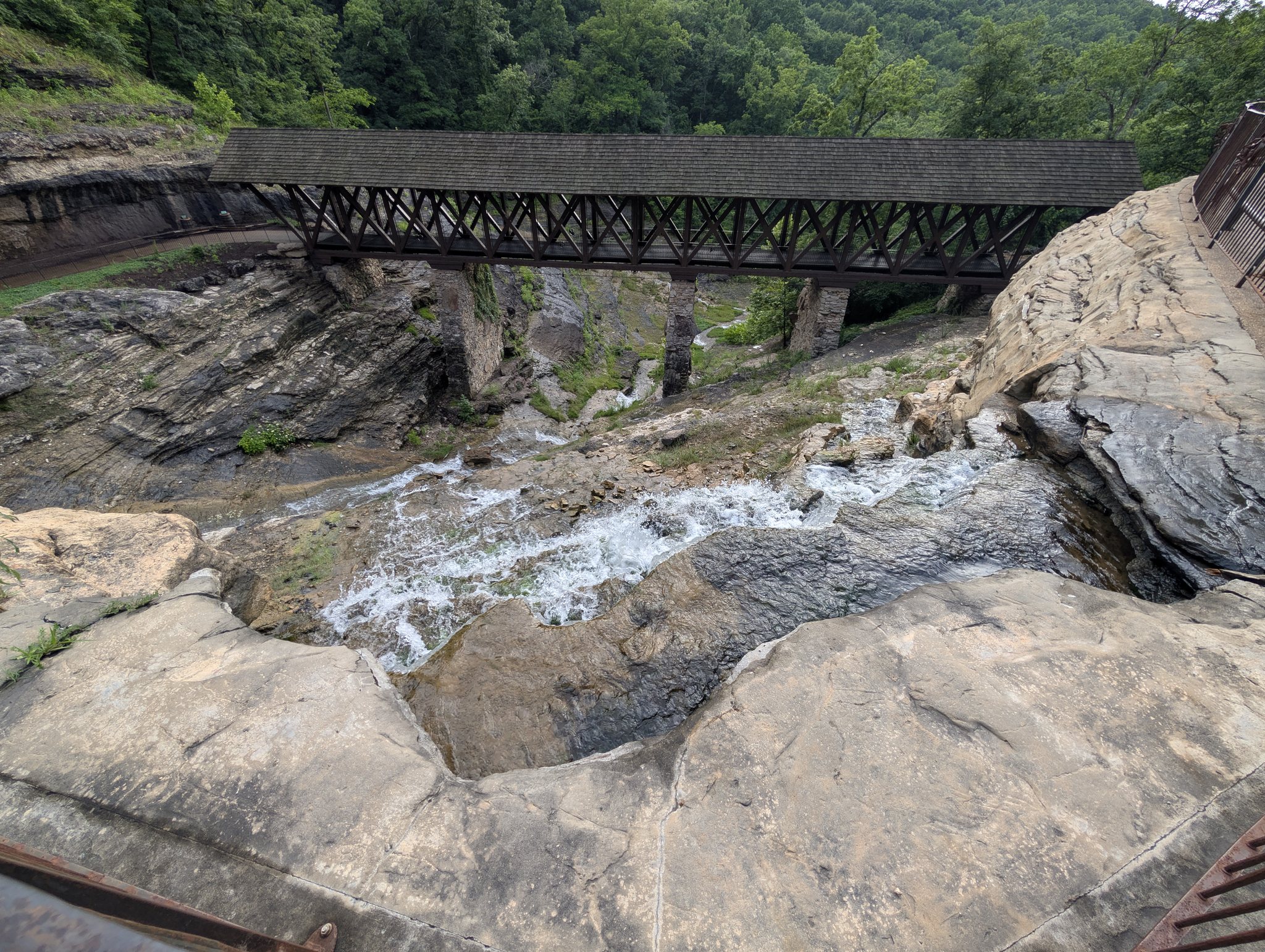 Wooden covered bridge spanning a rocky waterfall gorge on the Top of the Rock canyon trails near Branson, Missouri