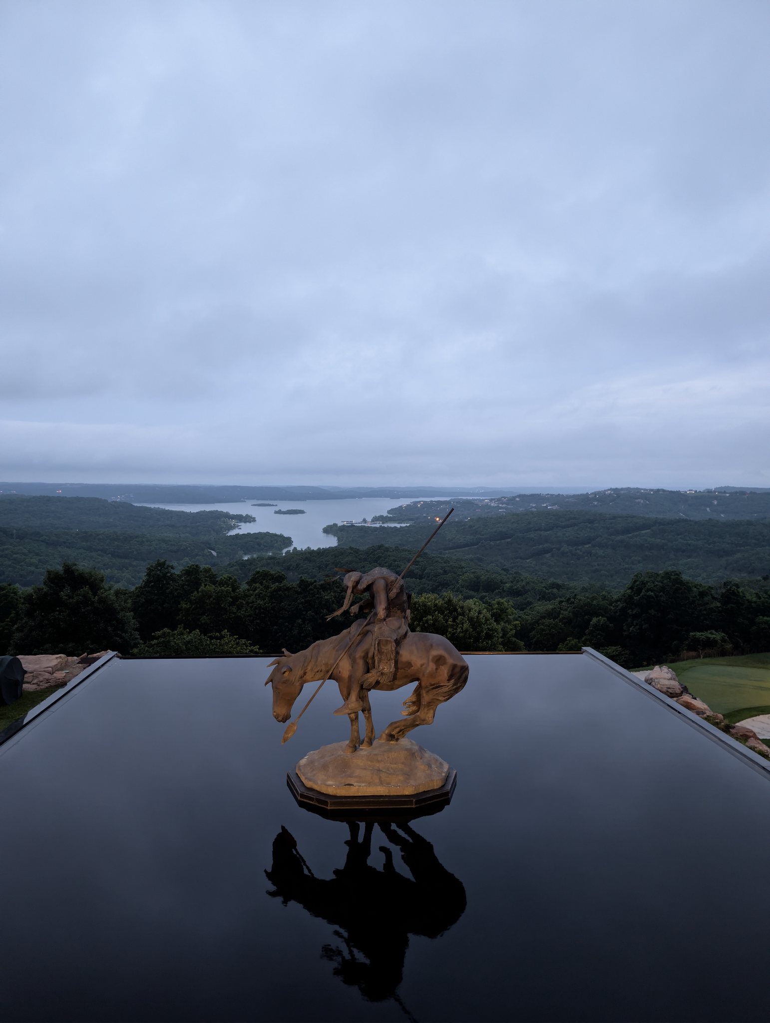 End of the Trail statue reflected in a dark pool overlooking Table Rock Lake at Top of the Rock near Branson, Missouri