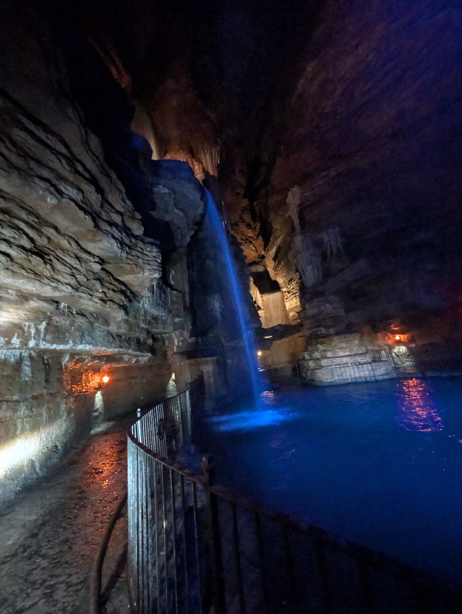 Blue-lit underground waterfall and walkway inside Lost Canyon at Top of the Rock near Branson, Missouri