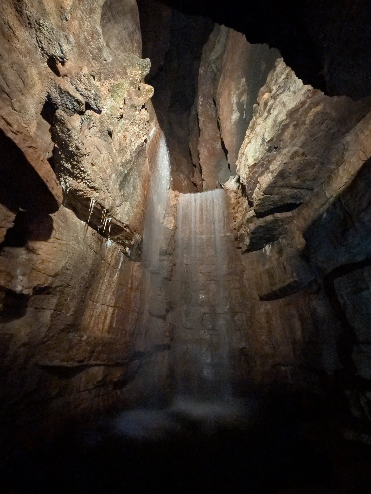 Tall underground waterfall cascading over layered rock in Lost Canyon at Top of the Rock near Branson, Missouri