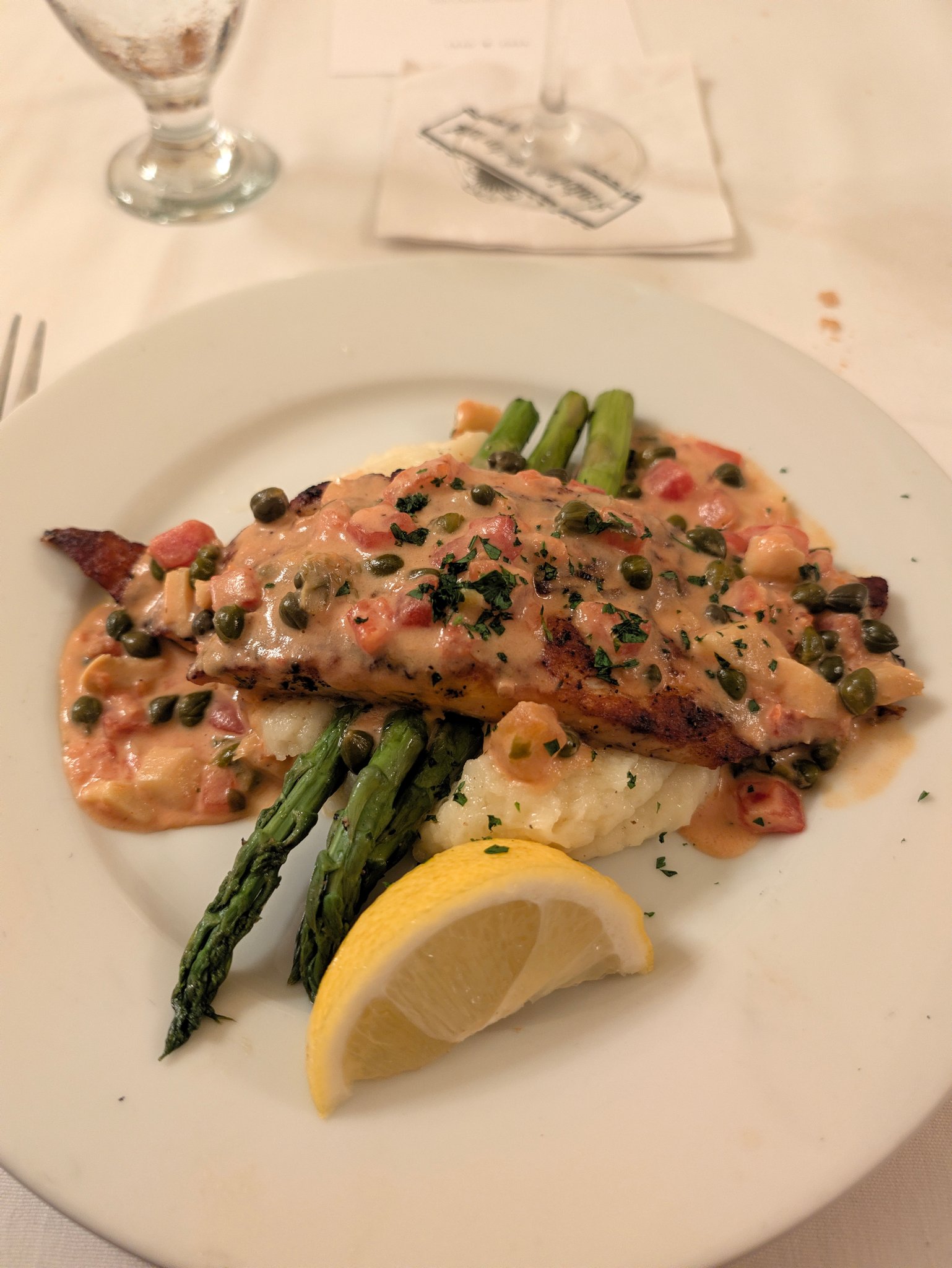Fish fillet in a light sauce with asparagus and a lemon wedge at Antoine's in New Orleans