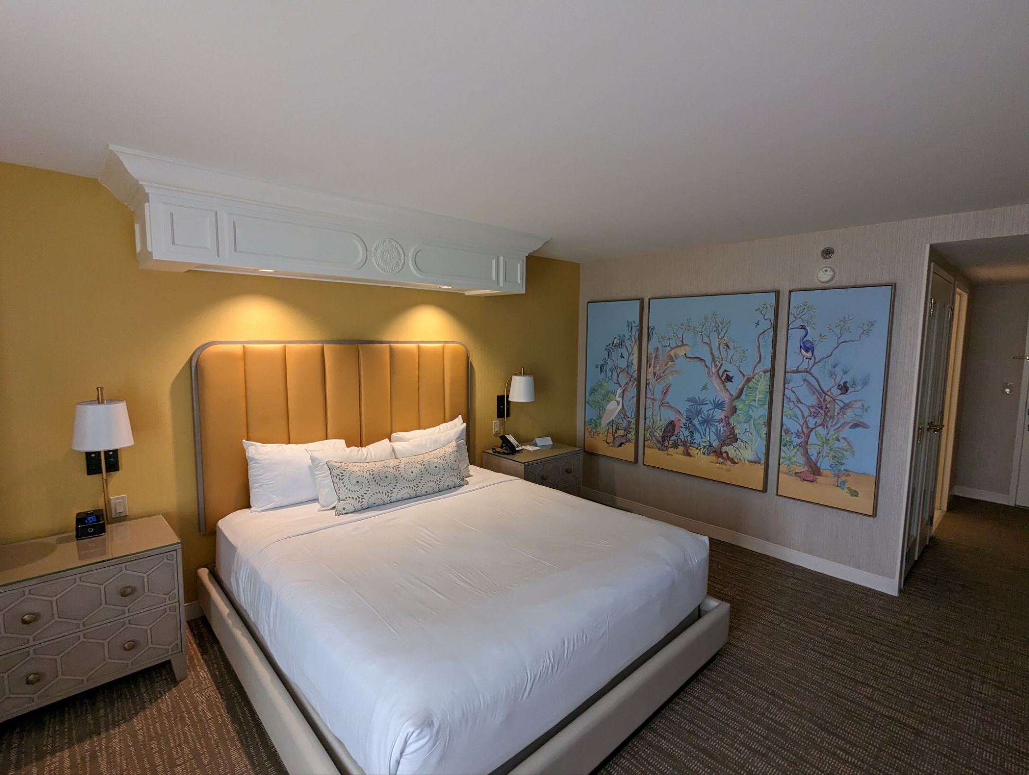 Our king room at Beau Rivage Biloxi with a gold headboard, honeycomb nightstands and coastal bird art
