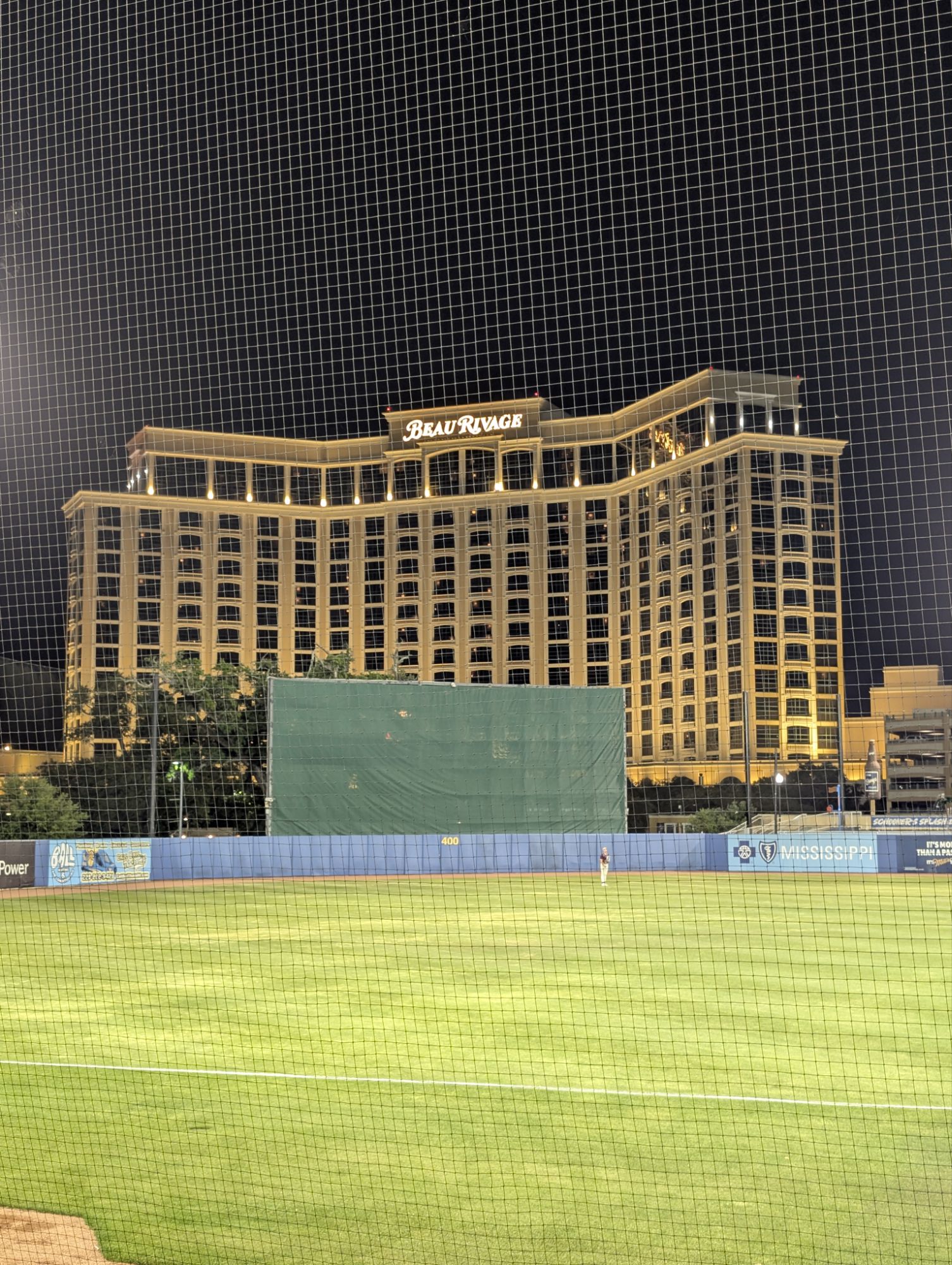 Night view across the Biloxi Shuckers outfield toward the lit Beau Rivage during our game