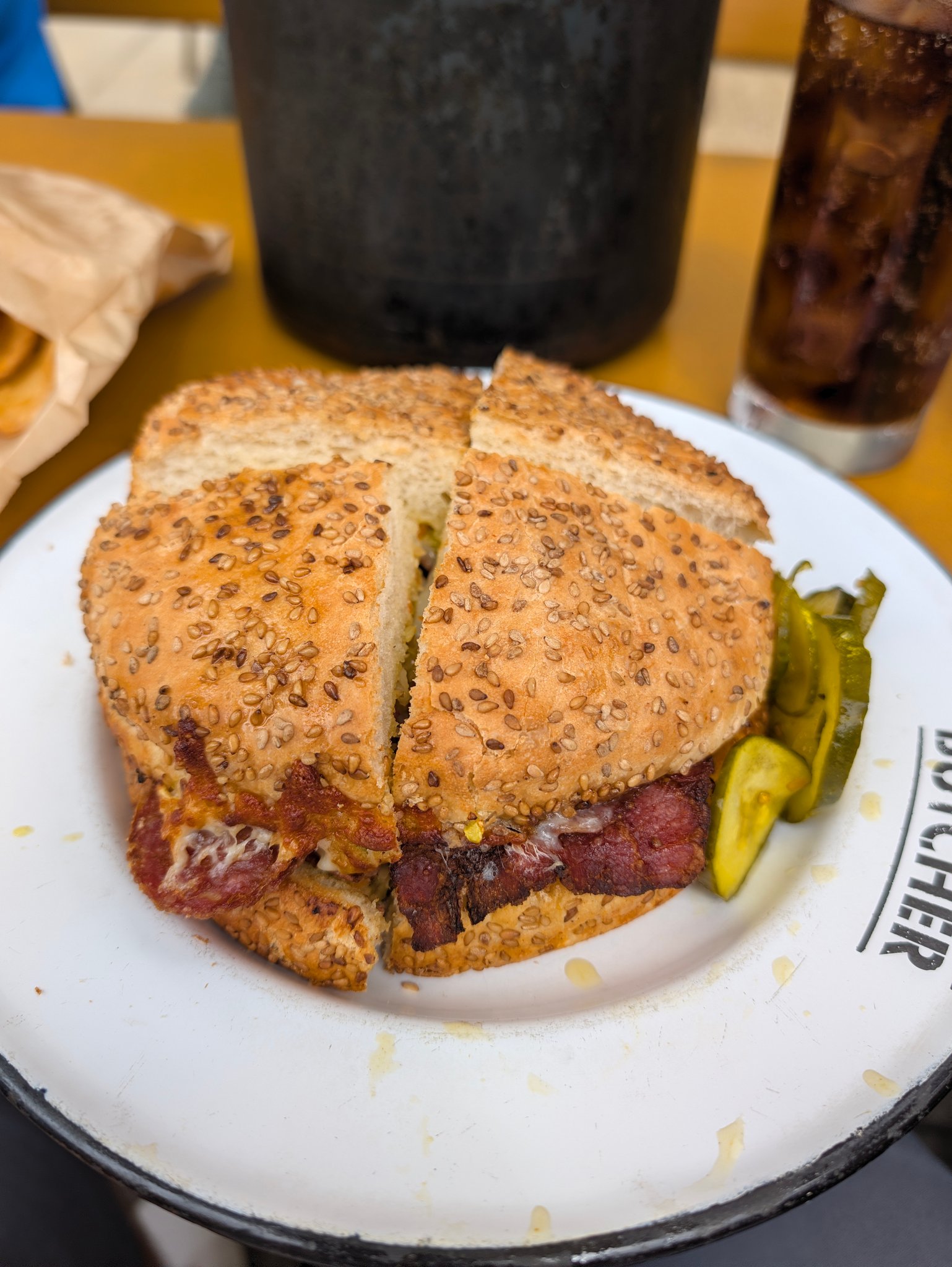 Overhead view of a halved muffuletta sandwich on a Cochon Butcher plate in New Orleans
