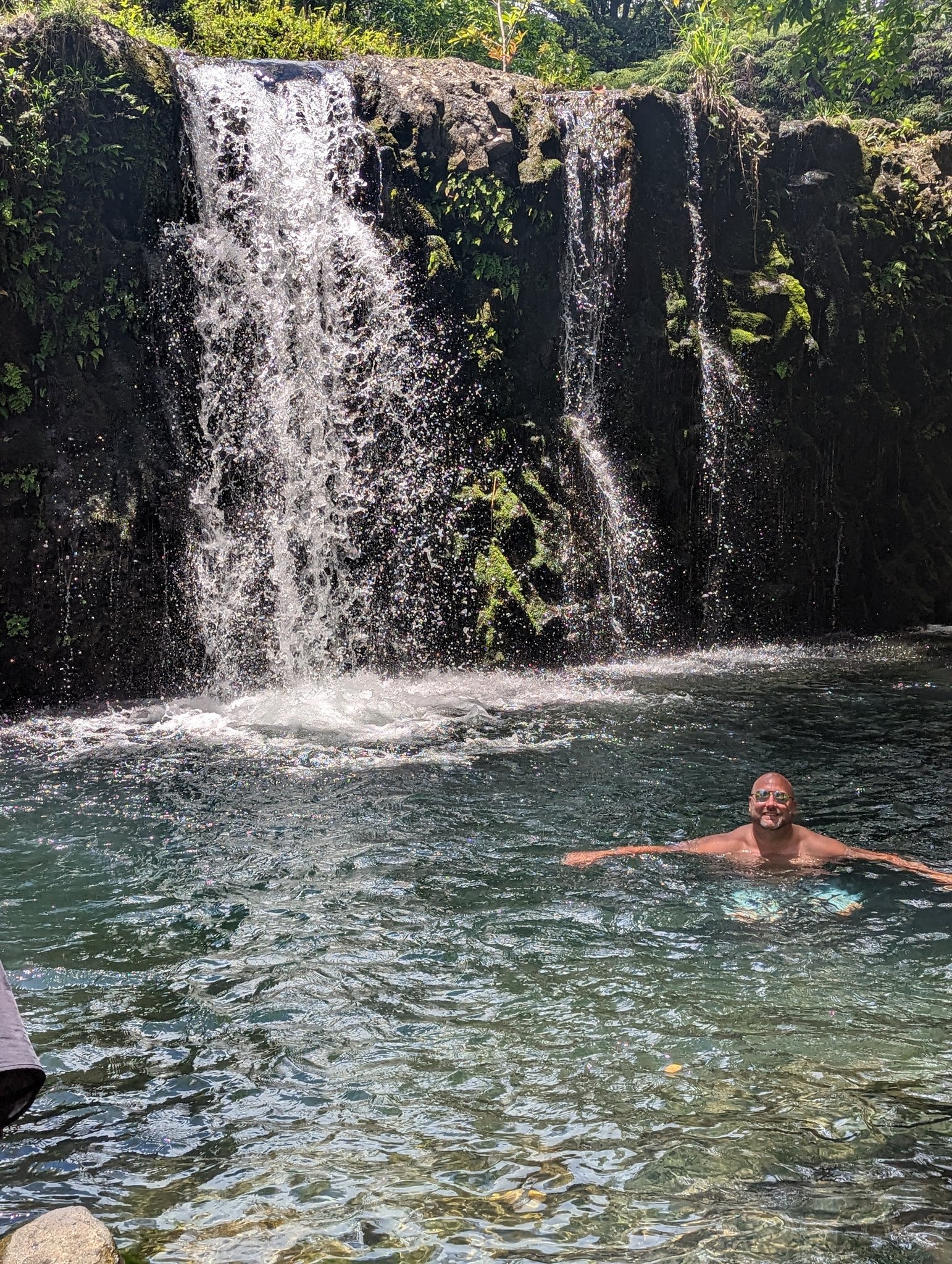Me swimming in a clear pool below a waterfall on the Road to Hana, Maui